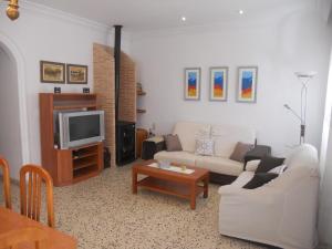 Playa de MiramarChalet cerca del mar的客厅配有白色沙发和电视