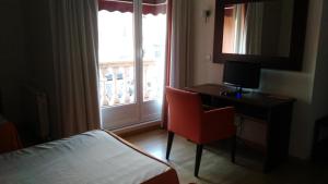 Trobajo del Camino阿尔法格美酒店的配有一张床、一张书桌和一扇窗户的酒店客房