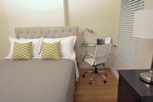 波士顿布里克套房酒店的一间卧室配有一张带桌子和椅子的床