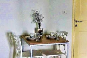华欣班皮普洛公寓的餐桌上摆放着盘子和花瓶