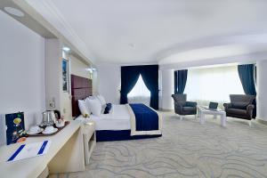 埃拉泽New Marathon Hotel的酒店客房,配有一张床、一张桌子和椅子