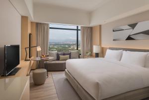 马尼拉Seda Vertis North的酒店客房设有一张大床和一台电视。