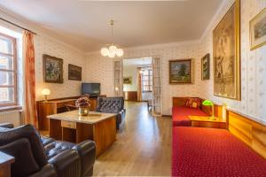 特热邦Penzion a restaurace U Míšků的客厅配有皮革家具和红色地毯。