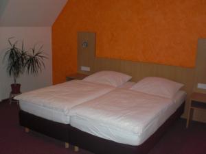 富尔达Landgasthof Schubbkoarn's Ruh的卧室内的一张带白色床单和枕头的床