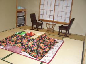 野沢卡多瓦几馆酒店的客厅配有桌子和花毯。