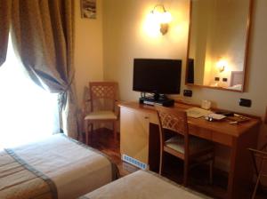 阿尔蒙诺圣巴特鲁姆卡莫乐堤酒店的酒店客房配有一张书桌、一台电视和一张床