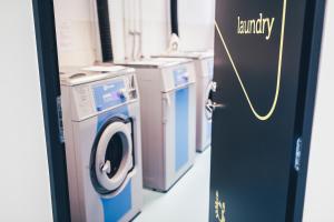 塔林Ülemiste Airport Hostel的洗衣房配有洗衣机和烘干机