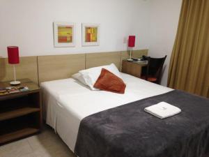 尼泰罗伊Camboinhas Beach Pousada的酒店客房,配有一张红色枕头的床