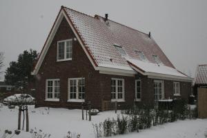 奥德多普B&B 't Meulweegje的屋顶上积雪的大砖屋