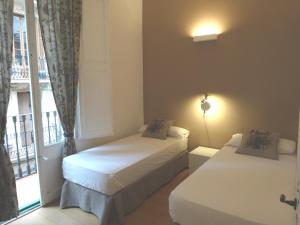 巴塞罗那巴塞罗那如家酒店的一间卧室设有两张床和窗户。
