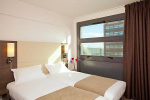 里尔欧洲里尔住宿及商务酒店的酒店客房设有两张床和窗户。
