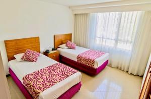麦德林Portal del Rodeo ApartaHotel的酒店客房设有两张床和窗户。