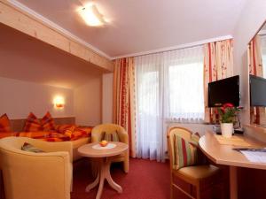 HäselgehrHaus Alpina的酒店客房带一张床、一张桌子和椅子