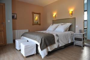 Orliénas乐克劳斯彭特酒店的一间卧室配有一张大床和两张凳子