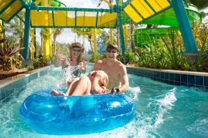 奥兰多The Grove Resort & Water Park Orlando的男子和女子在游泳池里木筏上骑着