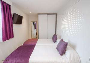 帕格拉波南特公寓酒店的卧室配有白色床和紫色枕头
