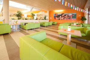 莱布尼茨莱布尼茨久发酒店的一间设有绿色沙发和桌子的餐厅