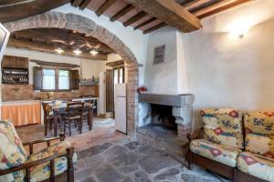 塞吉阿诺La villa della quercia的厨房以及带石制壁炉的客厅。