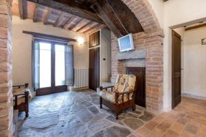 塞吉阿诺La villa della quercia的客厅设有石制壁炉和椅子