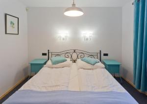 西维德尼察巴尔科萨卡提克旅馆的一间卧室配有一张带两张蓝色桌子的床