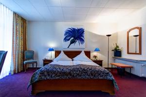 海德堡里贾纳酒店的一间卧室配有一张挂着蓝色画作的床铺。