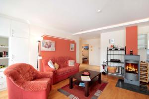 宾茨Villa Daphne & Danae by Rujana的客厅设有红色的沙发和壁炉