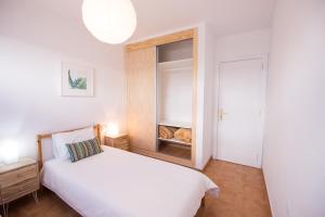 科拉雷侯Surfers Retreat的卧室配有白色的床和橱柜。