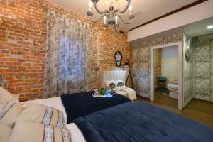 桑坦德Center Suite Santander的砖墙卧室配有一张床和一张沙发