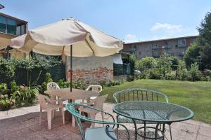 卢卡德拉罗萨阿菲卡梅瑞酒店的庭院里配有桌椅和遮阳伞