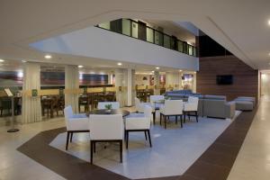 马塞约里兹家庭服务套房酒店的大楼内一家带白色椅子和桌子的餐厅