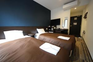 东京东京上野北千住尤班酒店的酒店客房,配有两张带毛巾的床