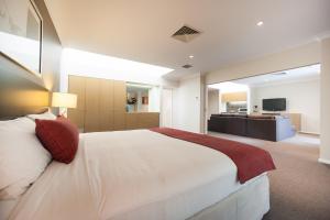 CabramattaRamada Hotel & Suites by Wyndham Cabramatta的卧室配有一张白色大床和电视。