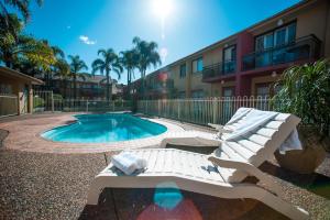 CabramattaRamada Hotel & Suites by Wyndham Cabramatta的一座游泳池,旁边设有躺椅