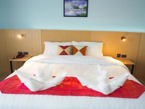 查汶苏梅岛城市酒店的一张白色的大床,上面有两条白色毛巾