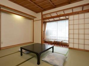 千曲市Riverside Uedakan的客房设有桌子和大窗户。
