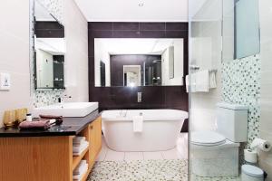 伊丽莎白港伊桑哥之门酒店的带浴缸、盥洗盆和卫生间的浴室