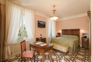 加尔尼亚诺Hotel Gardenia al Lago的一间卧室配有一张床、一张桌子和一张桌子