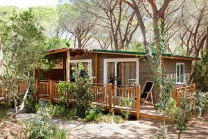 卡斯蒂里昂纳·德拉佩马雷玛圣苏西露营酒店的树林中的一个小屋,设有门廊