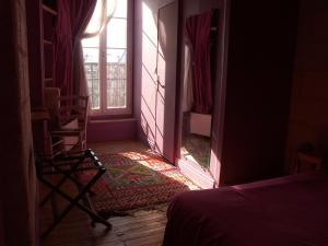 昂古莱姆帕莱斯酒店的客房设有床、窗户和椅子。
