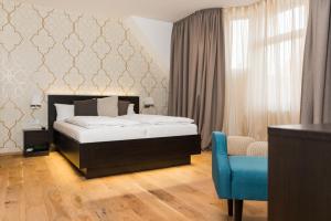 海德堡海德堡艾克泽冷兹酒店的一间卧室配有一张床和一张蓝色椅子