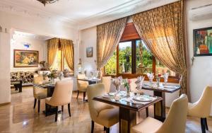 马拉喀什冬季秘密套房花园摩洛哥传统庭院住宅的用餐室设有桌椅和窗户。