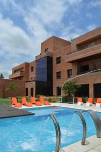 科尔多瓦内佩尔酒店 的一座带橙色椅子的游泳池和一座建筑
