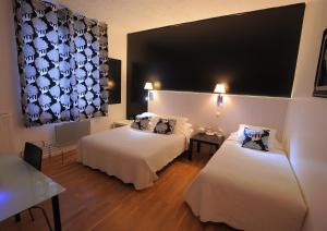图尔意大利人酒店的酒店客房设有两张床和大窗户。