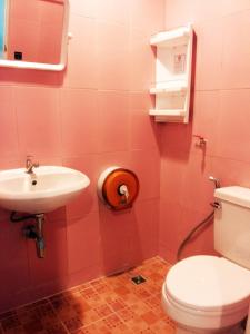 芭东海滩芭东旺旺旅舍的粉红色的浴室设有卫生间和水槽