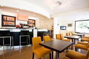 切塞纳蒂科Hotel Apollo的一间带桌椅的餐厅和一间酒吧