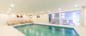 坎波图雷斯黑尔维格酒店的一个带椅子和桌子的房间的游泳池