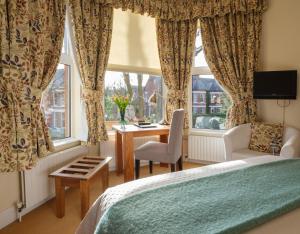 贝尔法斯特罗斯蕾旅馆的一间卧室配有一张床、一张书桌和一个窗户。