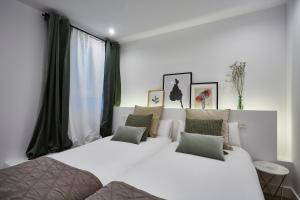 马德里Apartamento junto a Plaza Mayor的一间卧室设有两张床和大窗户