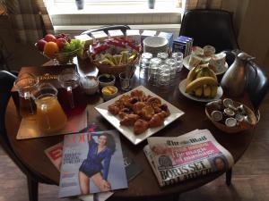 诺里奇黑天鹅宾馆的一张木桌,上面放着食物和杂志