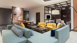 圆石城Hyatt Place Austin/Round Rock的客厅配有蓝色的沙发和黄色的椅子
